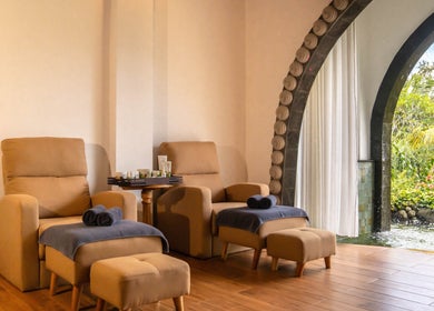 Relaxing lounge at Dirasha Wellness in Bali, Bali, ID with plush chairs and a garden view.