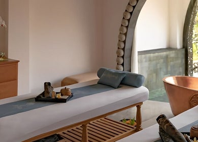 Luxurious spa room at Dirasha Wellness in Bali, Bali, ID, featuring massage beds and a copper bathtub.