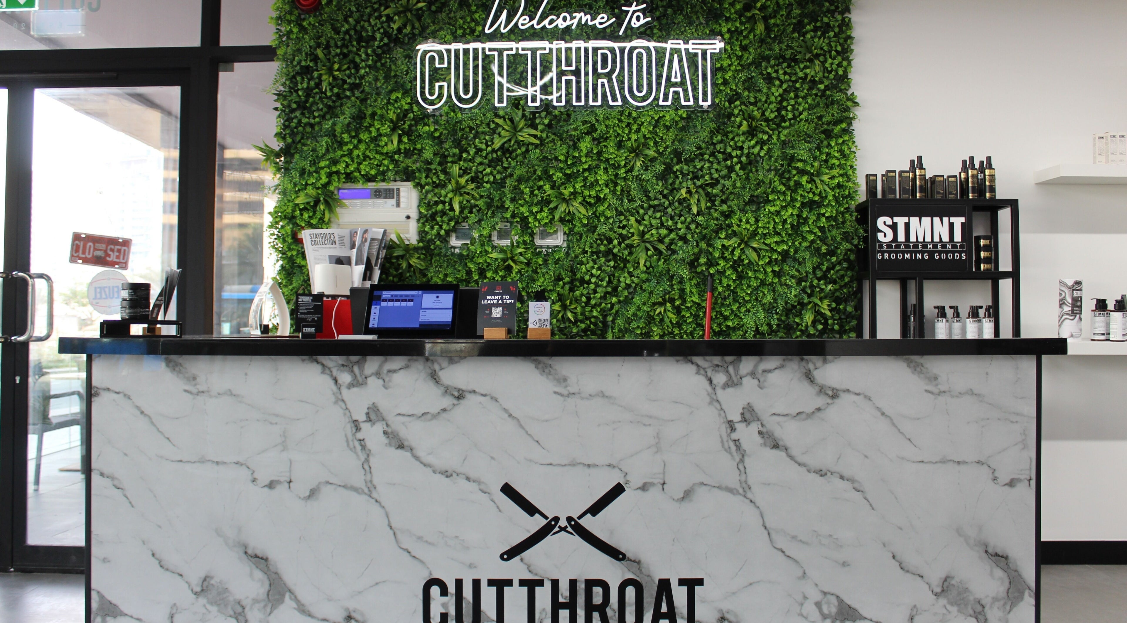 Cutthroat reception area with green wall and marble desk, Dubai, Dubai, AE.