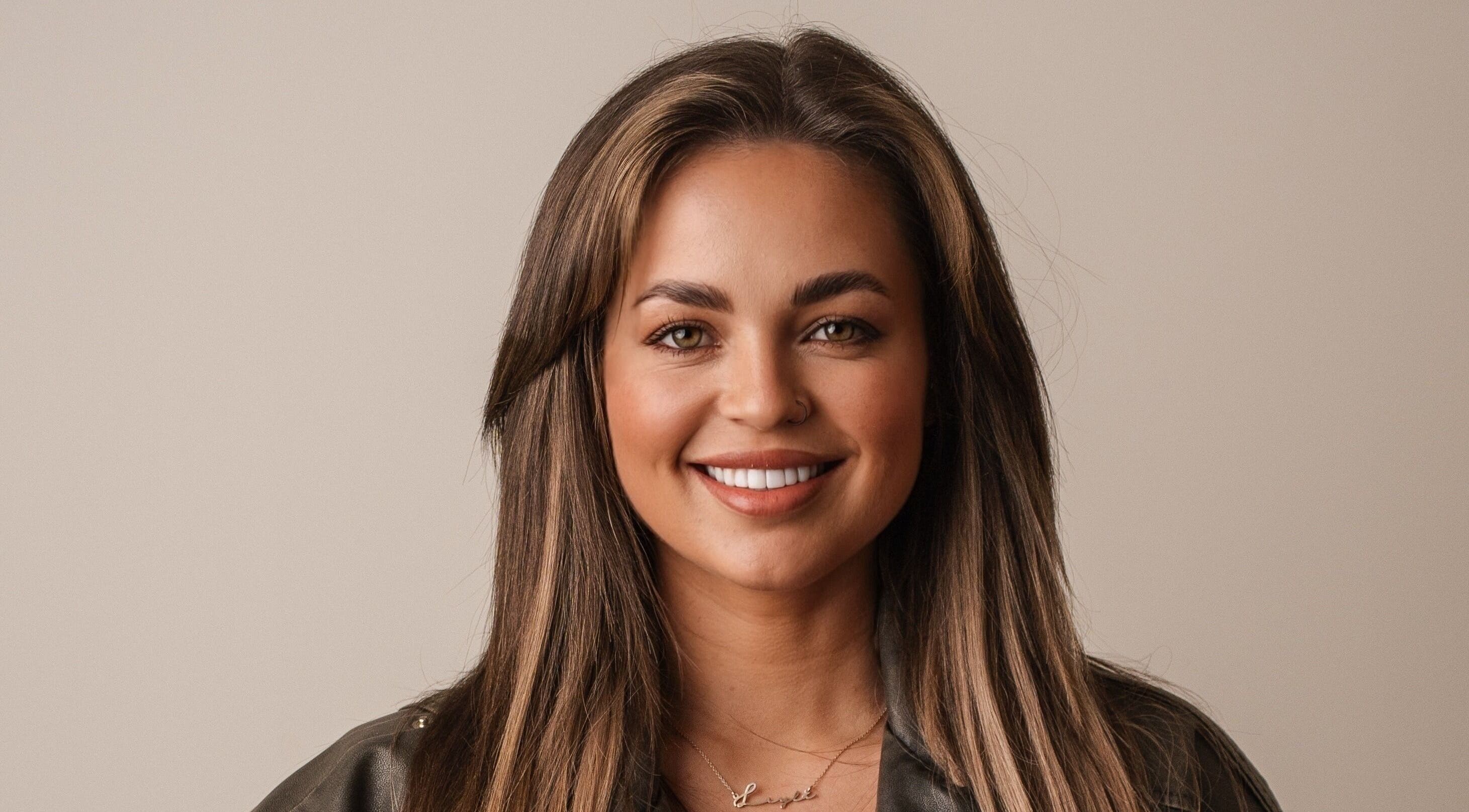 Woman smiling warmly, showcasing hairstyling at Eyeline, Gorey, County Wexford, IE.