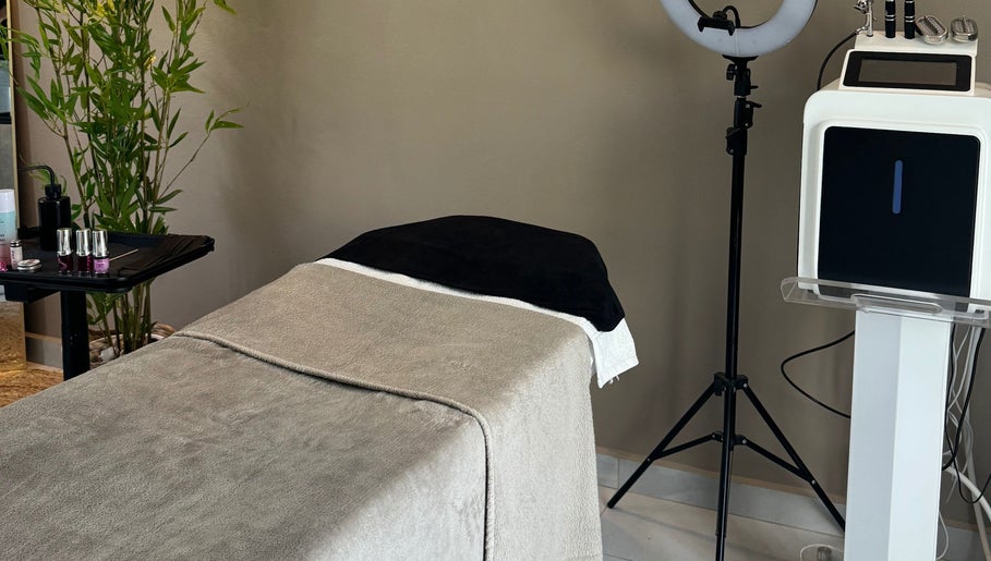 Elegant treatment room at 24K Beauty Studio in Noord, AW with spa bed and beauty equipment.