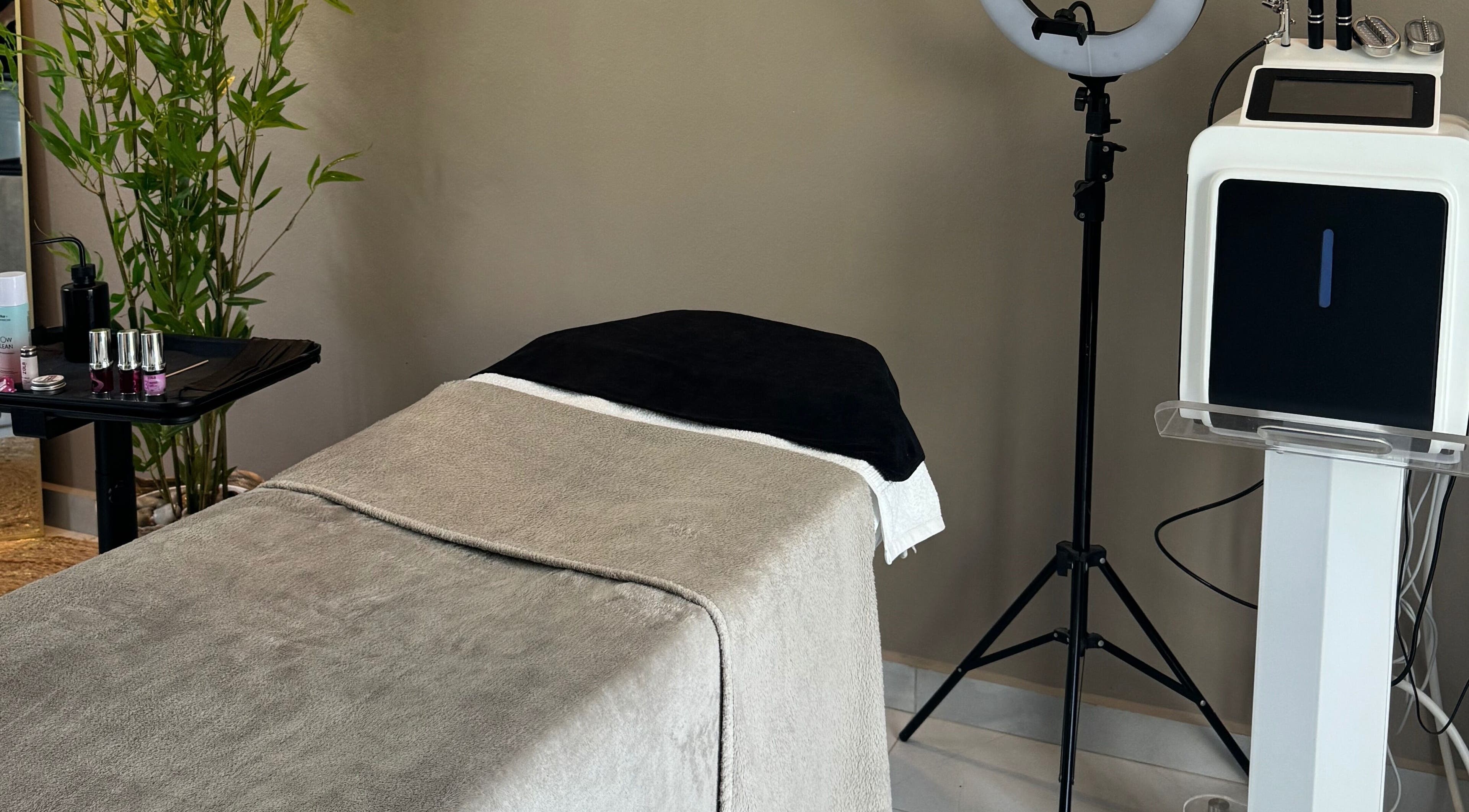 Elegant treatment room at 24K Beauty Studio in Noord, AW with spa bed and beauty equipment.