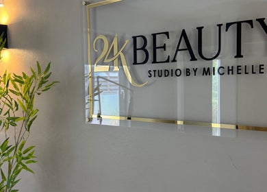 Entrance sign of 24K Beauty Studio at Noord, AW, showcasing modern elegance with gold accents.
