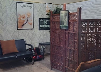 Relaxing lobby area of L'Image Parfaite Day Spa, Port of Spain, TT with seating and decorative divider.