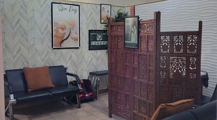 Relaxing lobby area of L'Image Parfaite Day Spa, Port of Spain, TT with seating and decorative divider.