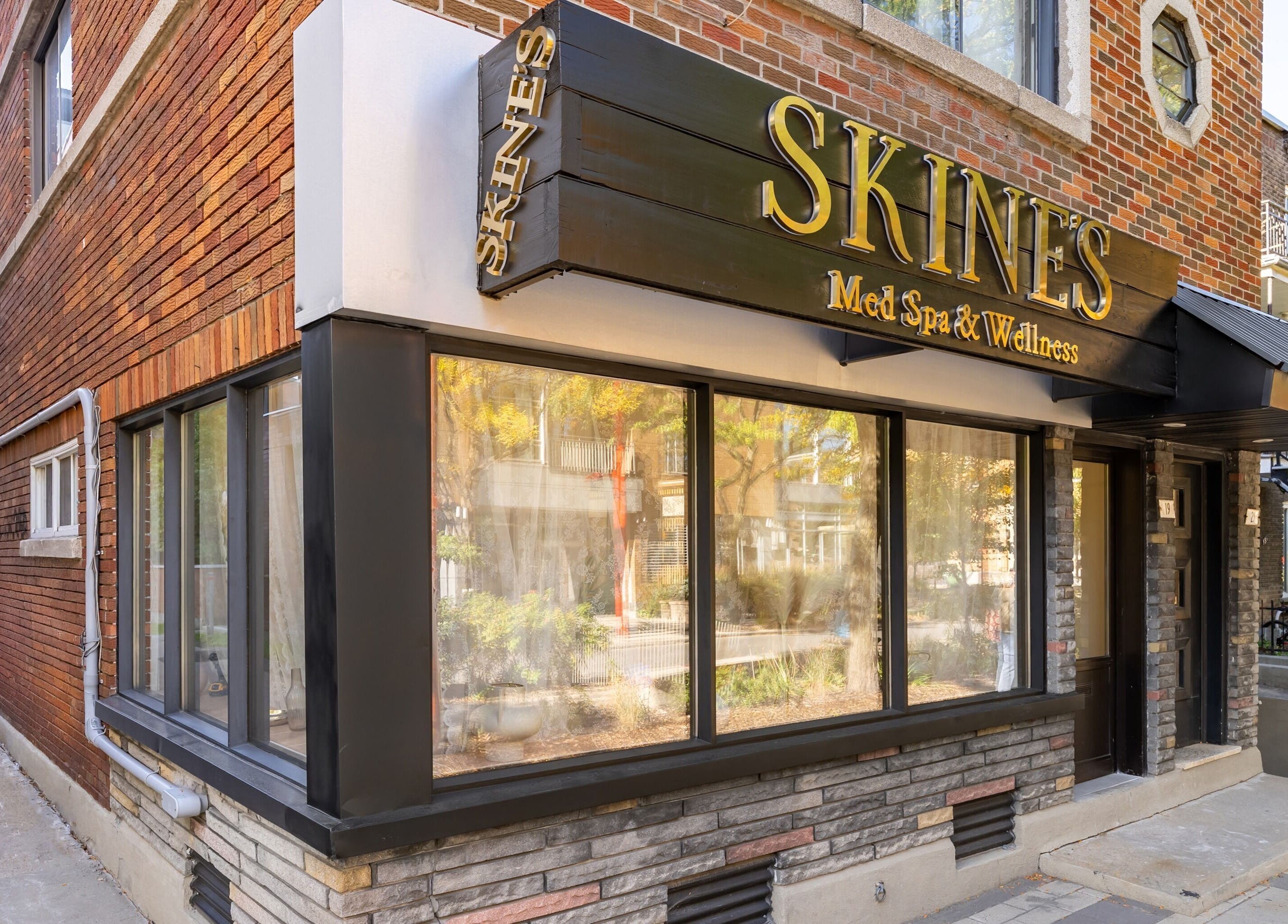 Entrée de Skines Head Spa à Montréal, Québec, CA avec panneau distinctif et fenêtre vitrée.
