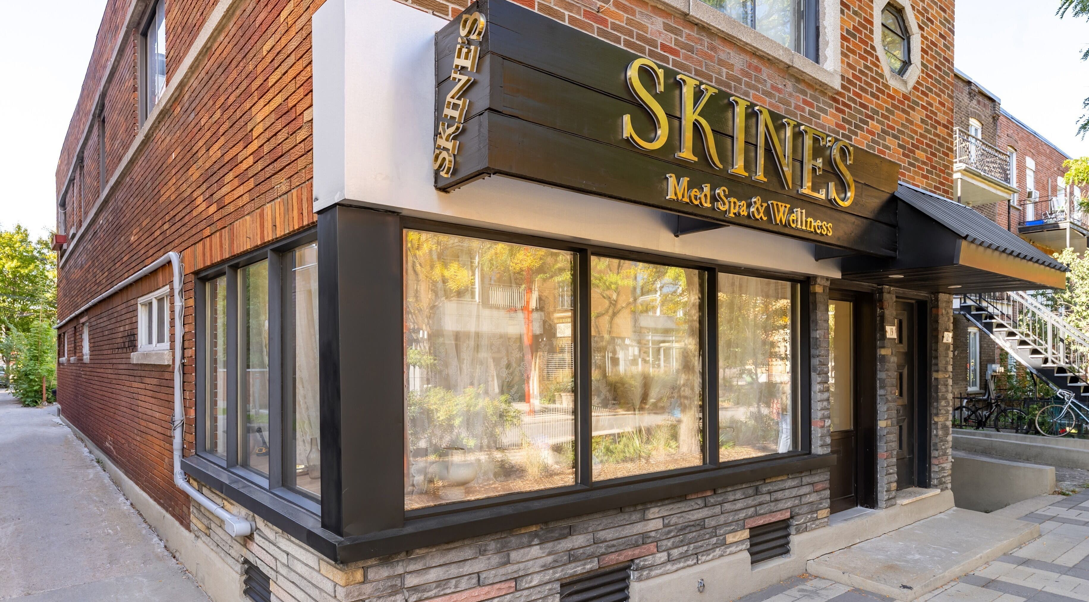 Entrée de Skines Head Spa à Montréal, Québec, CA avec panneau distinctif et fenêtre vitrée.