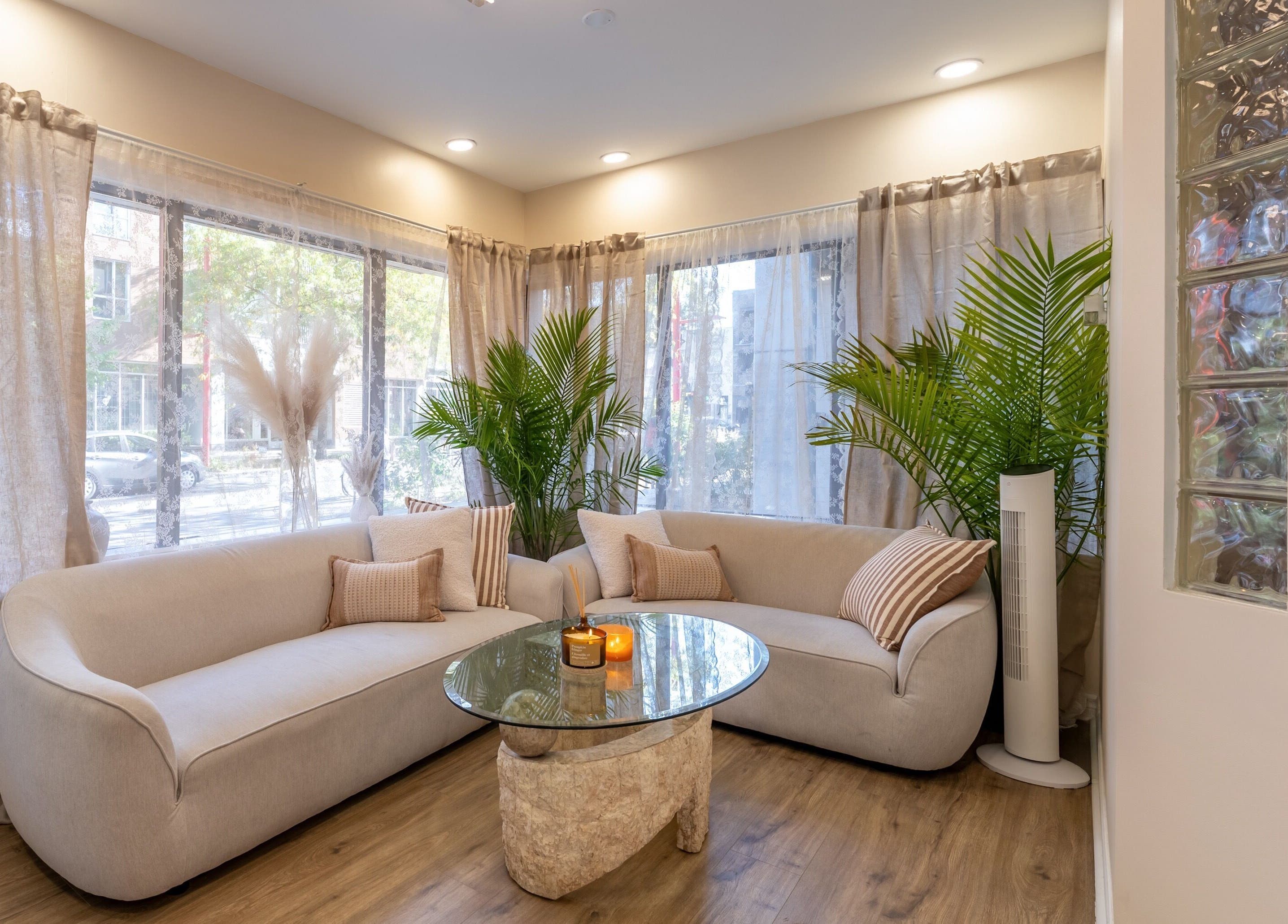 Intérieur moderne et lumineux de Skines Head Spa à Montréal, Québec, CA, avec canapé et plantes décoratives.