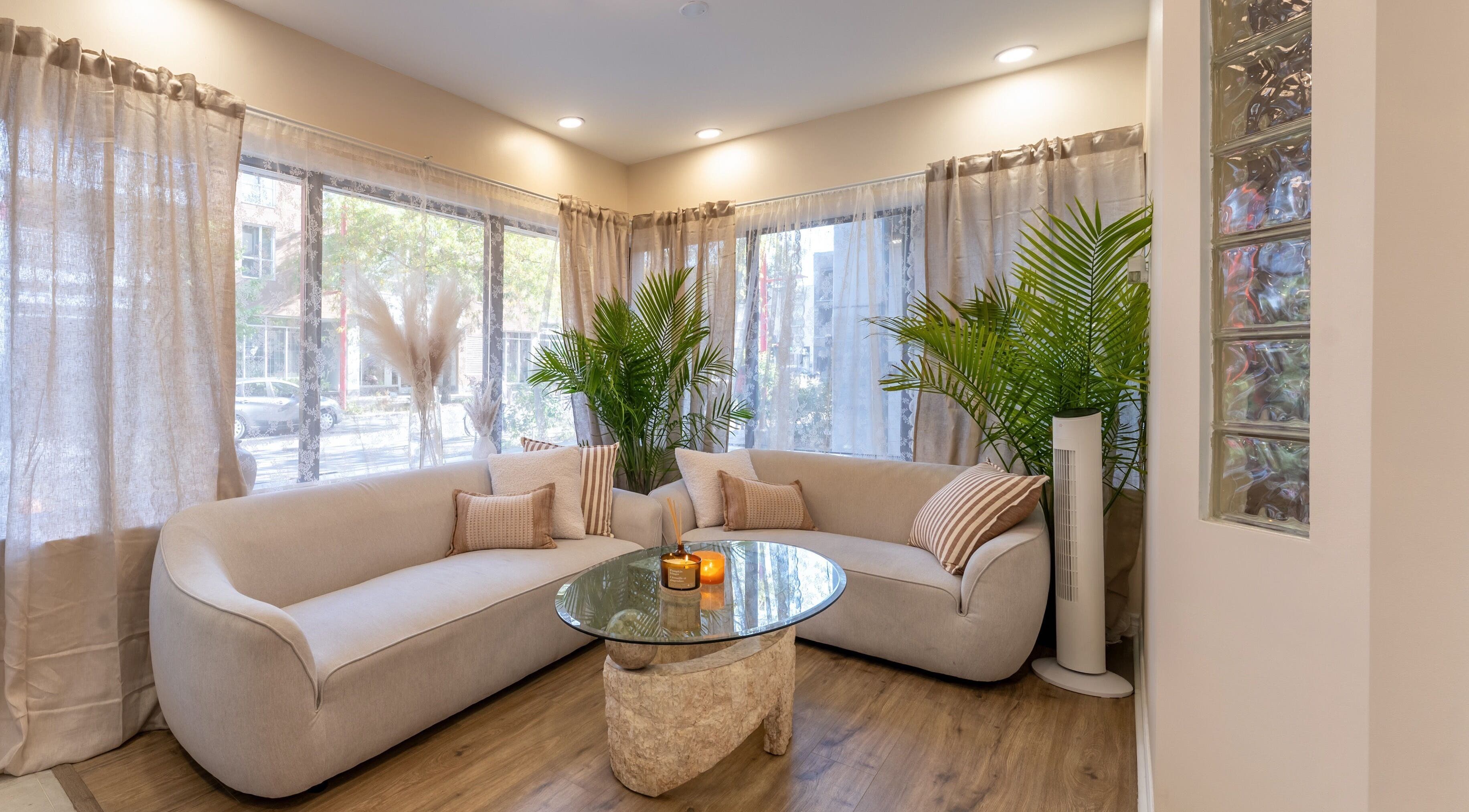Intérieur moderne et lumineux de Skines Head Spa à Montréal, Québec, CA, avec canapé et plantes décoratives.