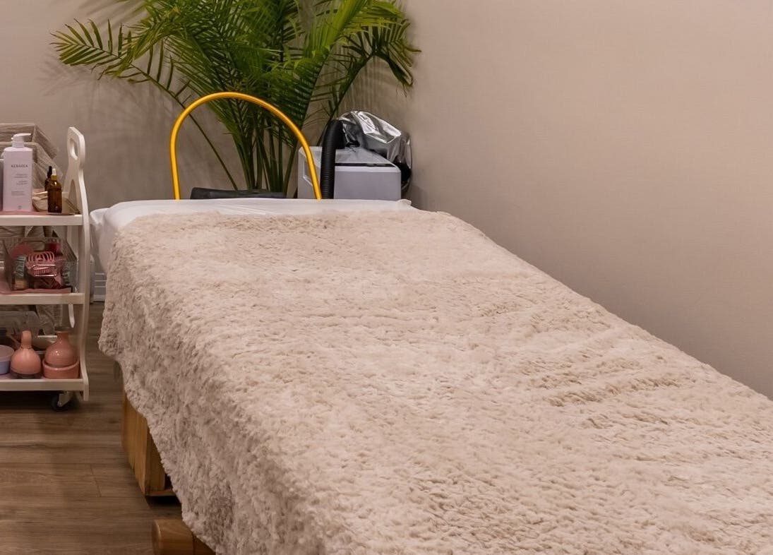 Salle de soin élégante chez Skines Head Spa, Montréal, Québec, CA, avec un lit de massage et des plantes apaisantes.