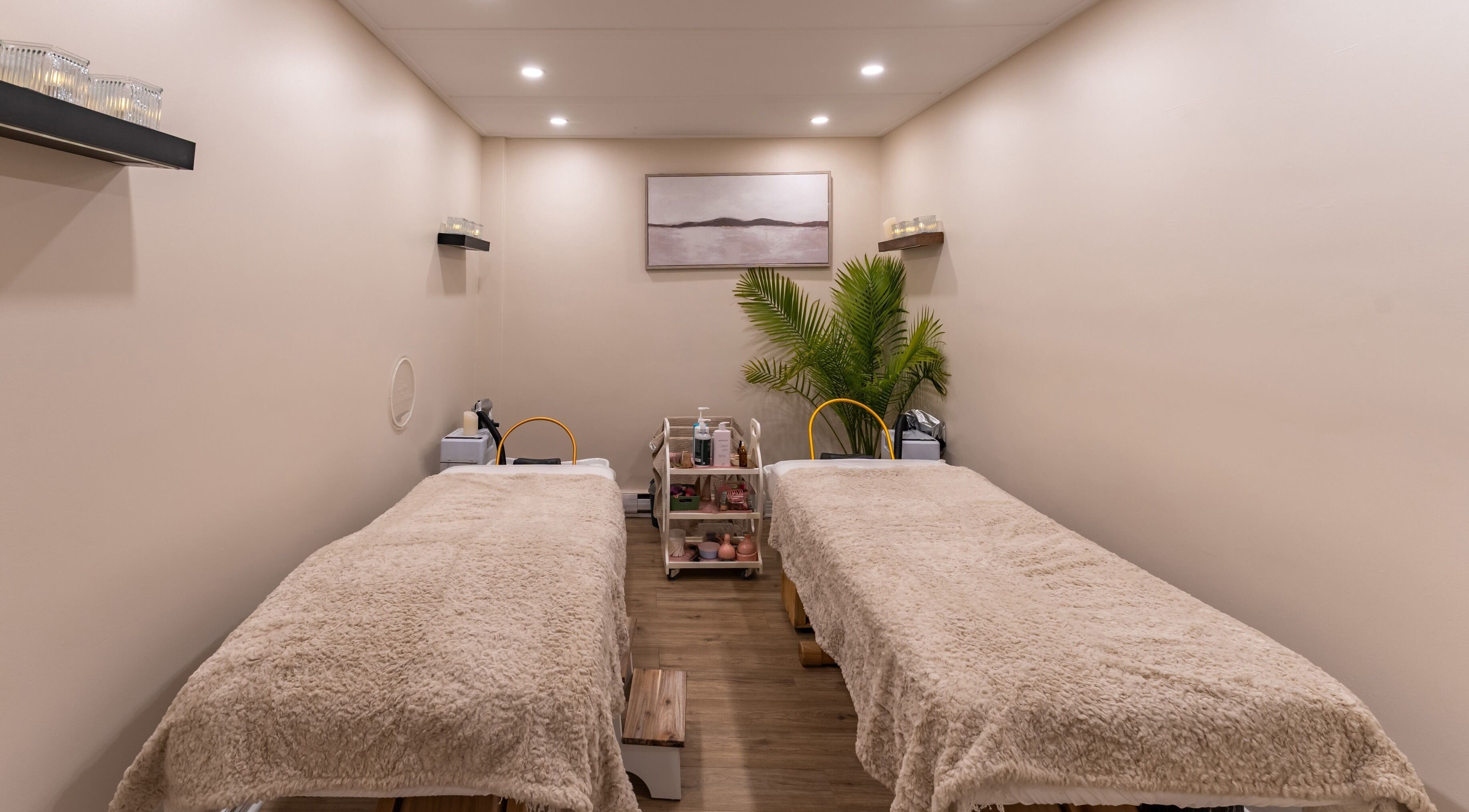 Salle de soins double à Skines Head Spa, Montréal, Québec, CA, avec lits cosy et déco apaisante.