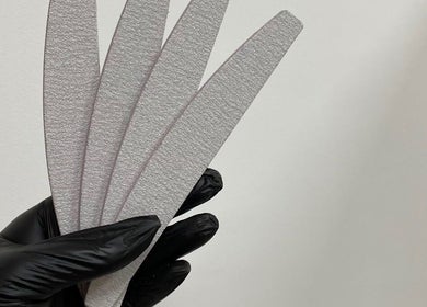 Zwarte handschoen houdt nagelvijlen vast bij Coconut Blend, Willemstad, CW. Ideaal voor professionele manicures.