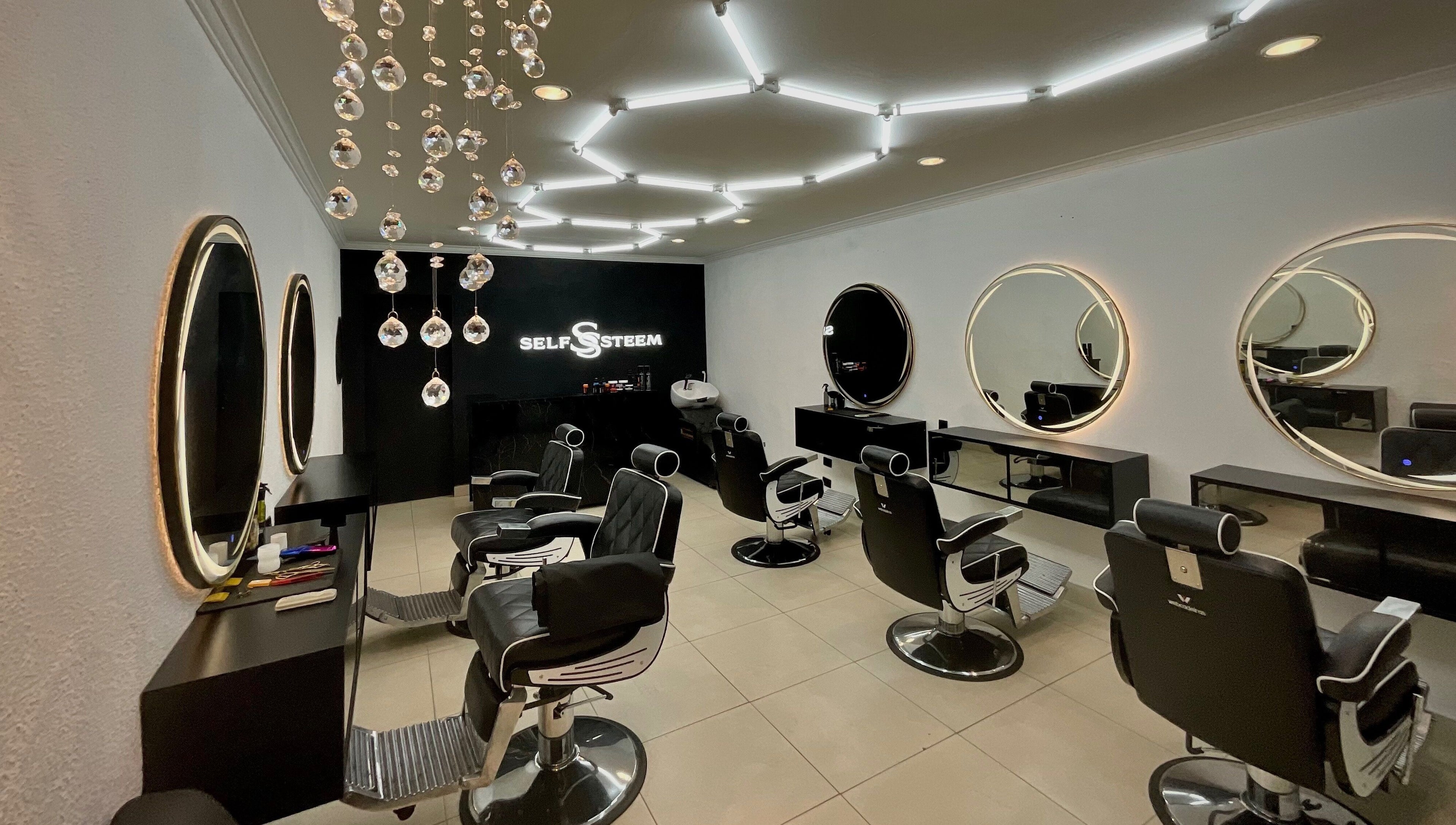 Interior moderno do Self Steem em Rondônia, Rondônia, BR, com cadeiras de cabeleireiro e espelhos iluminados.