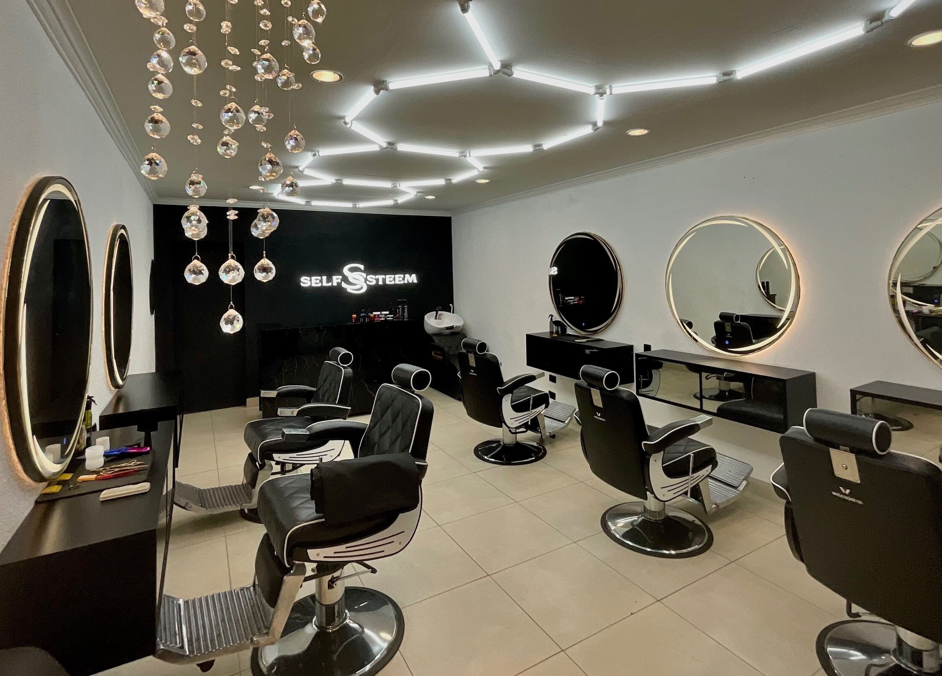 Interior moderno do Self Steem em Rondônia, Rondônia, BR, com cadeiras de cabeleireiro e espelhos iluminados.