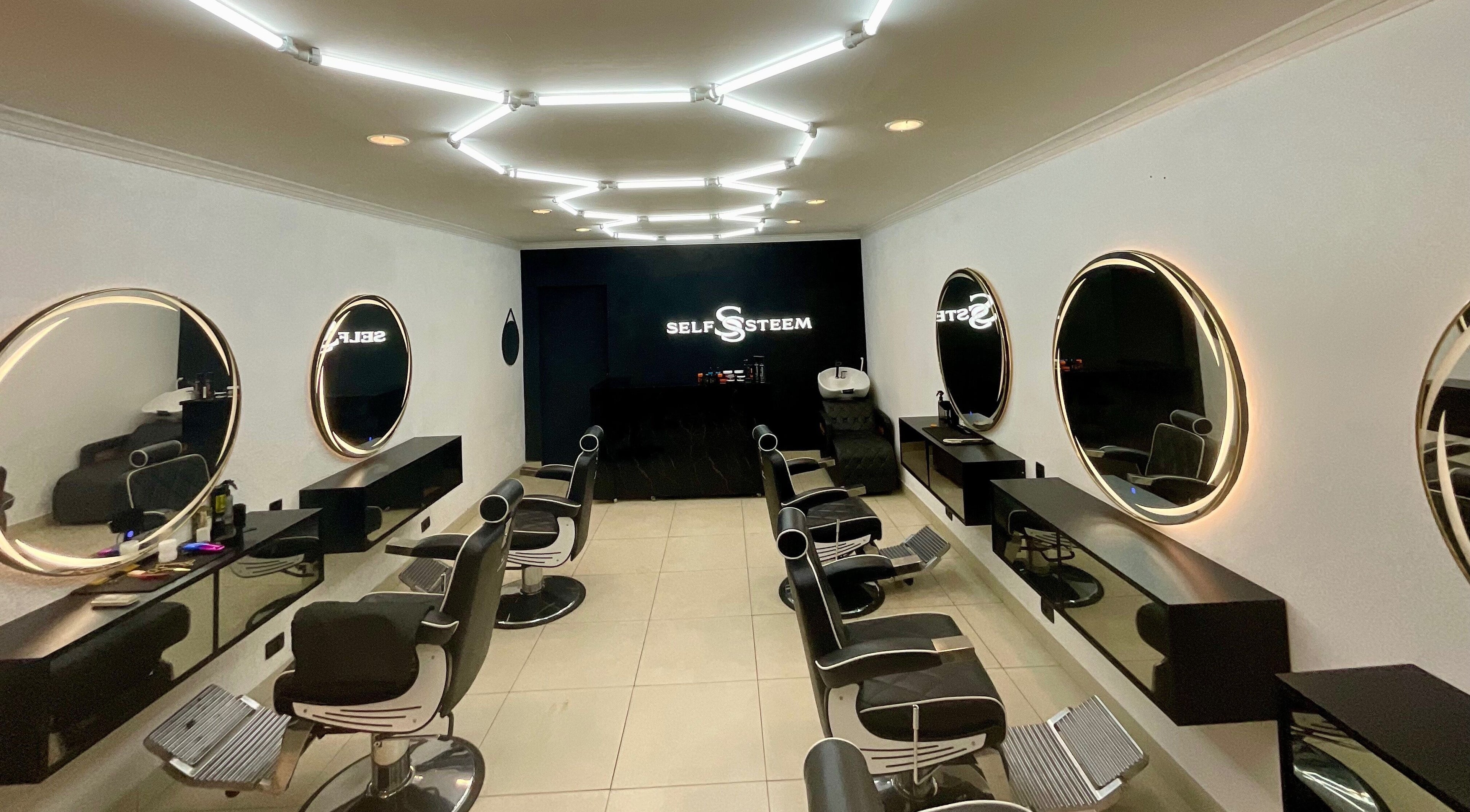 Interior sofisticado da Self Steem em Rondônia, Rondônia, BR, com espelhos iluminados e cadeiras de salão.