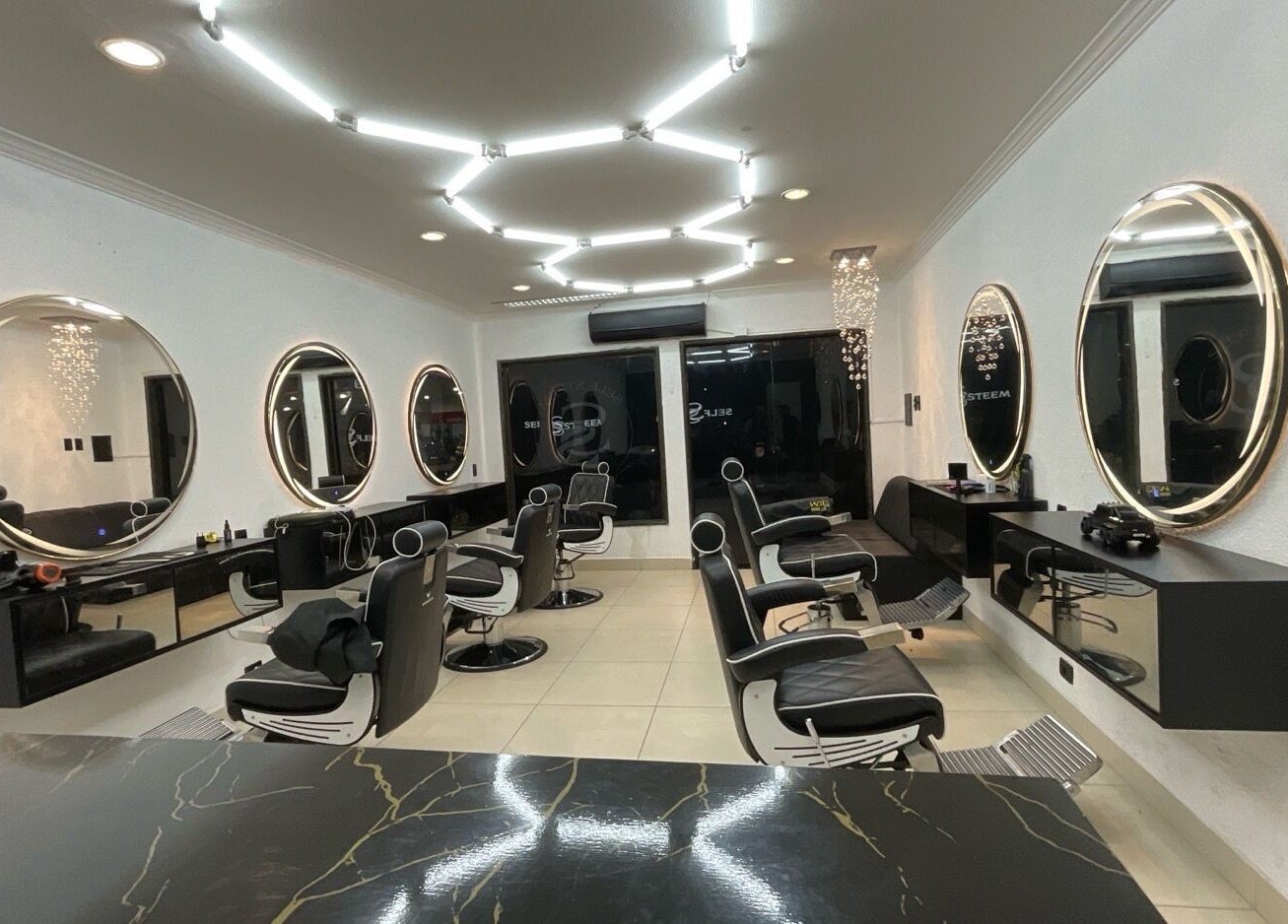 Interior moderno do salão Self Steem em Rondônia, Rondônia, BR, com espelhos circulares e cadeiras alinhadas.