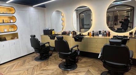 Sleek, modern barber chairs and mirrors in Quintessential Man, Redfern, New South Wales, AU.