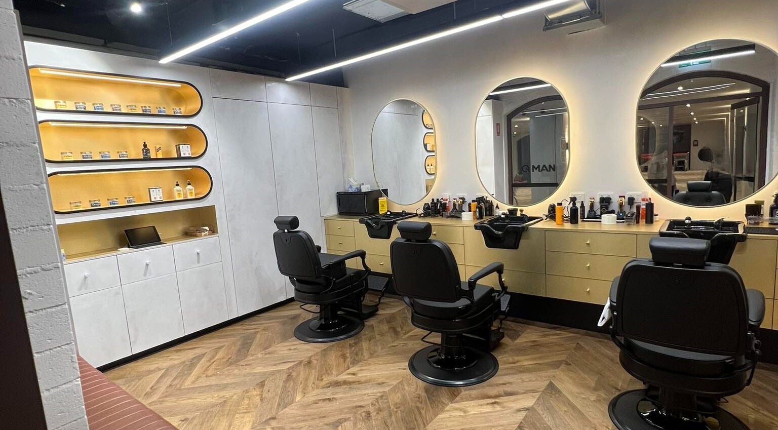 Modern barber interior at Quintessential Man, Redfern, New South Wales, AU with stylish chairs and mirrors.
