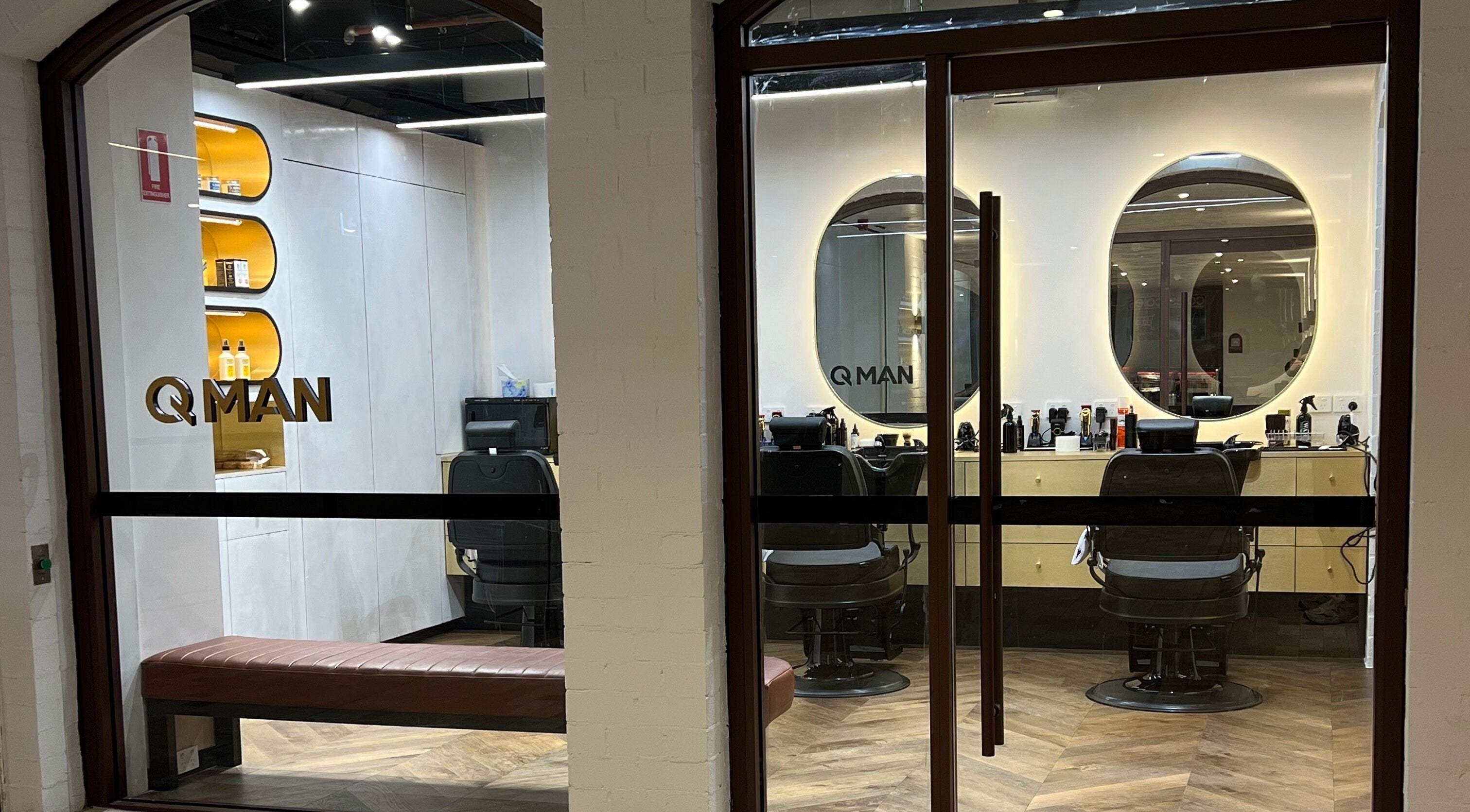 Sleek interior of Quintessential Man barbershop in Redfern, NSW, showcasing modern decor and stylish seating.