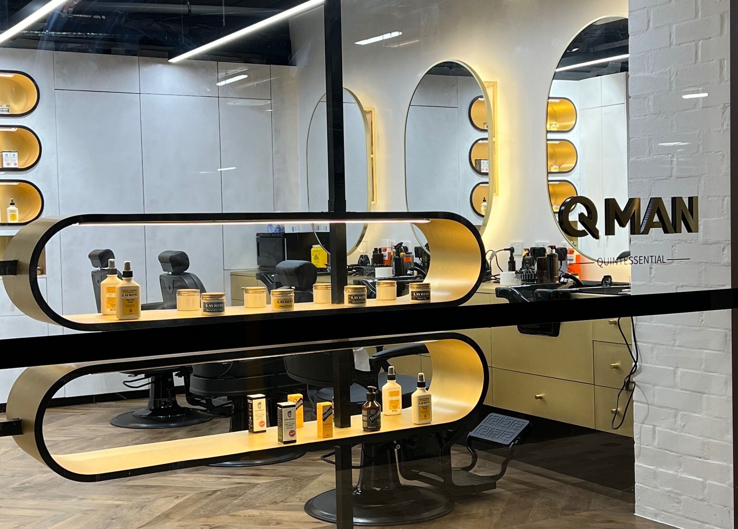 Sleek interior of Quintessential Man barbershop, Redfern, New South Wales, AU with stylish chairs and product display.