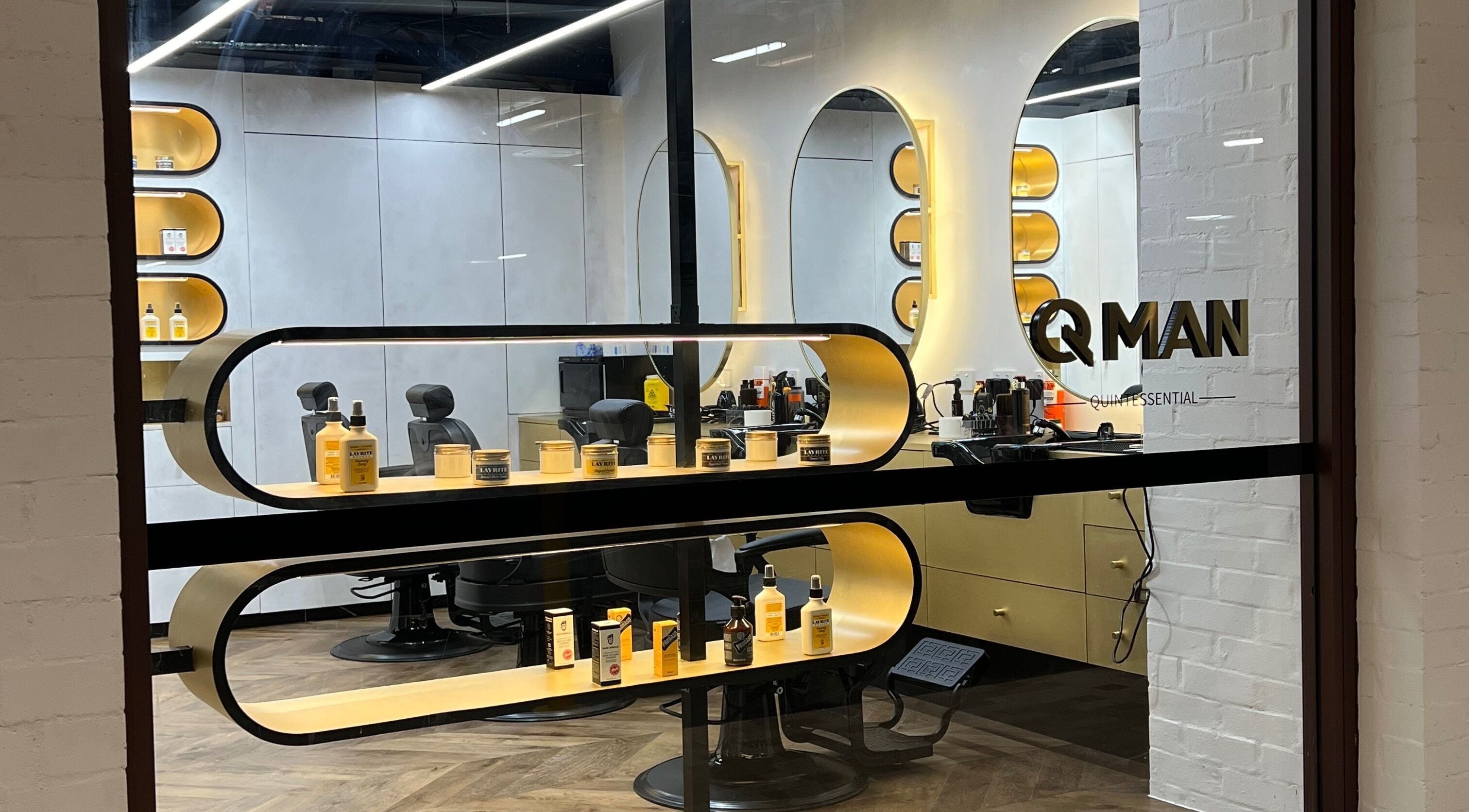 Sleek interior of Quintessential Man barbershop, Redfern, New South Wales, AU with stylish chairs and product display.