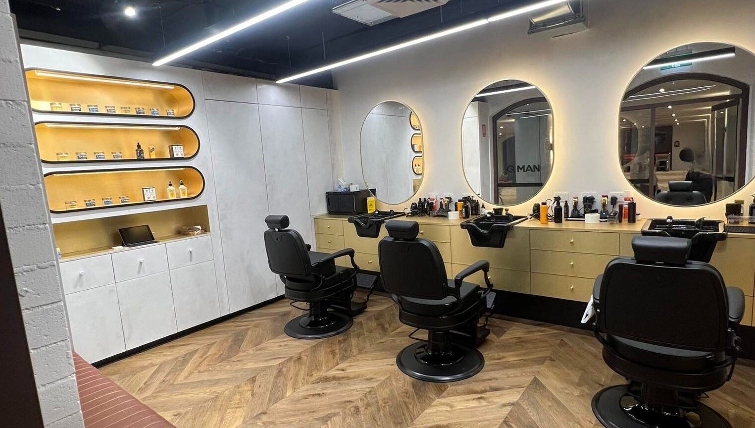 Modern barber chairs and mirrors at Quintessential Man in Redfern, New South Wales, AU.