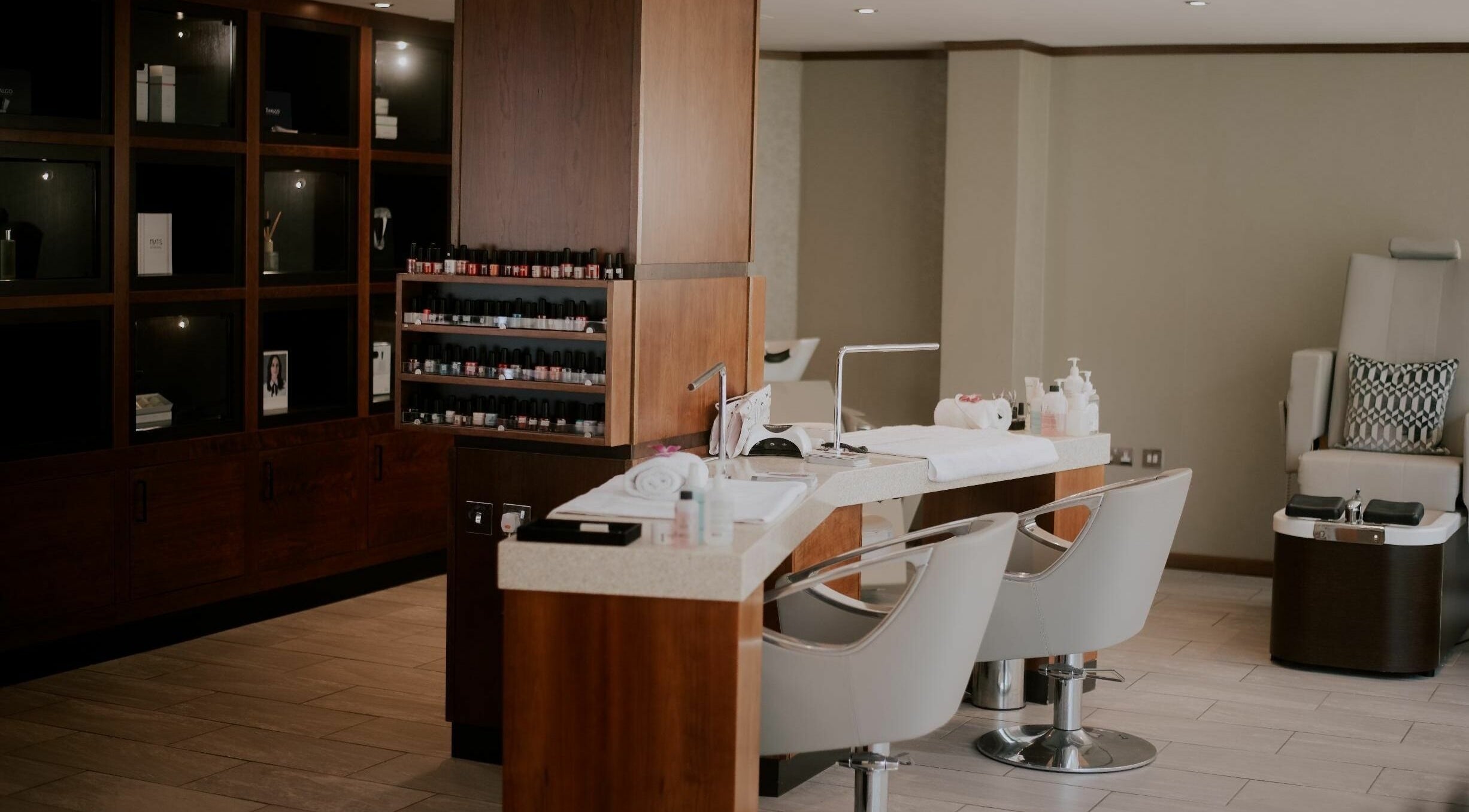 Modern nail salon at Costley & Costley Hoteliers Ltd, Troon, Scotland, GB. Features sleek chairs and nail polish display.