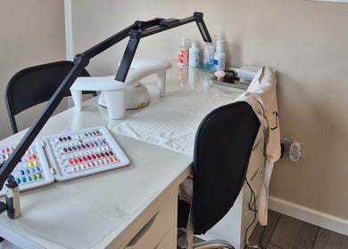 Manicure station at Fingers and Toes, Mexborough, England, GB, featuring nail polish samples and tools.