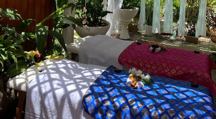 Rustgevende massagebedden bij Pura Vida by Johanny, Willemstad, Curaçao, CW, omgeven door groene planten.