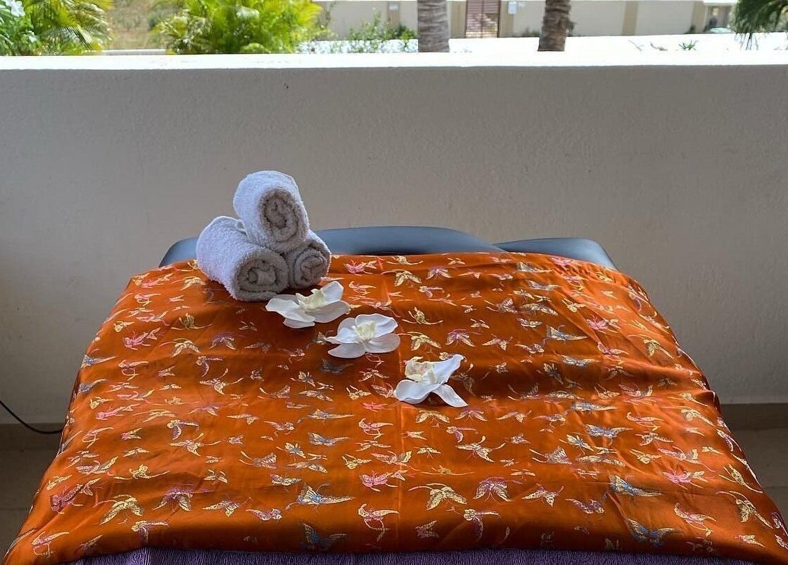 Masseertafel met bloemen en handdoeken bij Pura Vida by Johanny, Willemstad, Curaçao, CW.