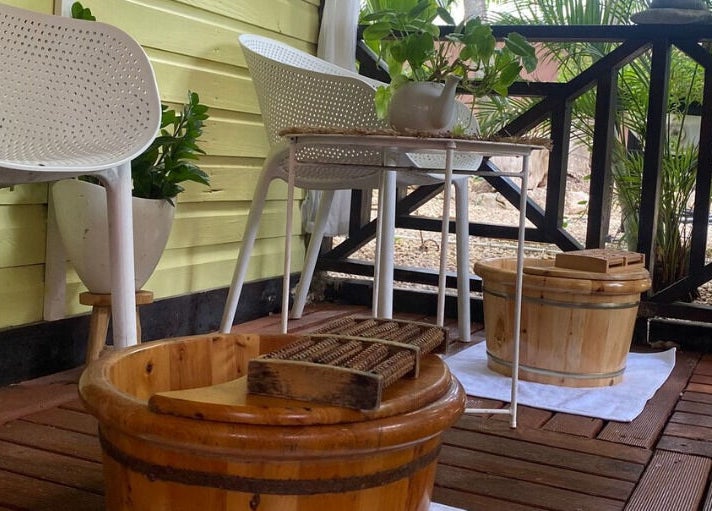 Ontspannend balkon bij Pura Vida by Johanny, Willemstad, Curaçao, CW met houten voetenbad en witte stoelen.