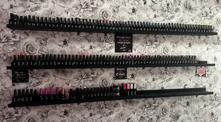 Nail polish display at Nails by Emma, Driffield, England, GB against floral wall.