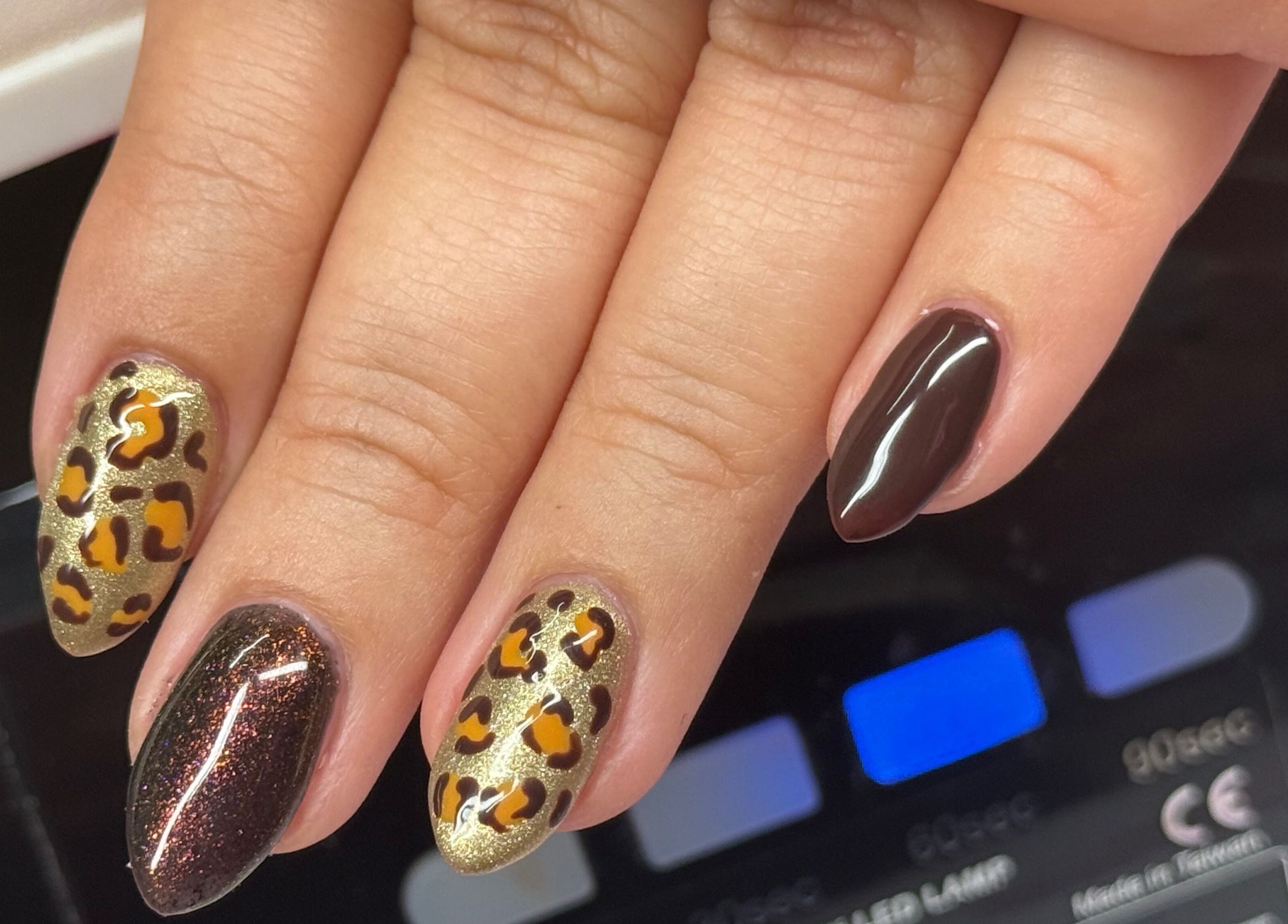 Leopard print nail art by Nails by Emma, Norton, England, GB. Detailed brown and gold design.