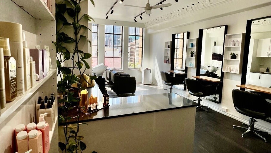 Stylish and modern interior of Bradley Rose Hair in Melbourne, Victoria, AU, featuring mirrors and seating.