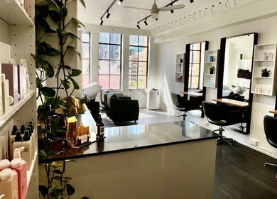 Stylish and modern interior of Bradley Rose Hair in Melbourne, Victoria, AU, featuring mirrors and seating.