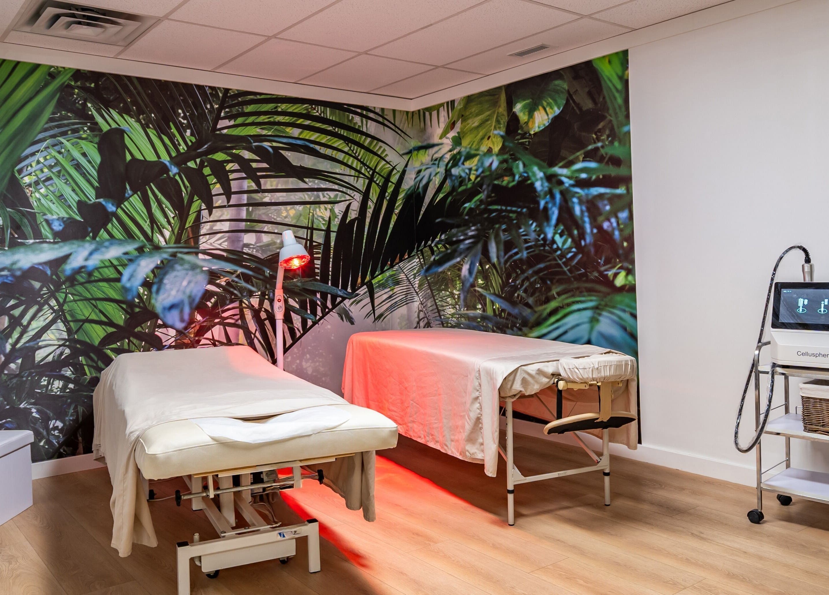 Relaxing treatment room at ERA Massage & Beauty in Calgary, Alberta, CA with tropical decor and massage tables.