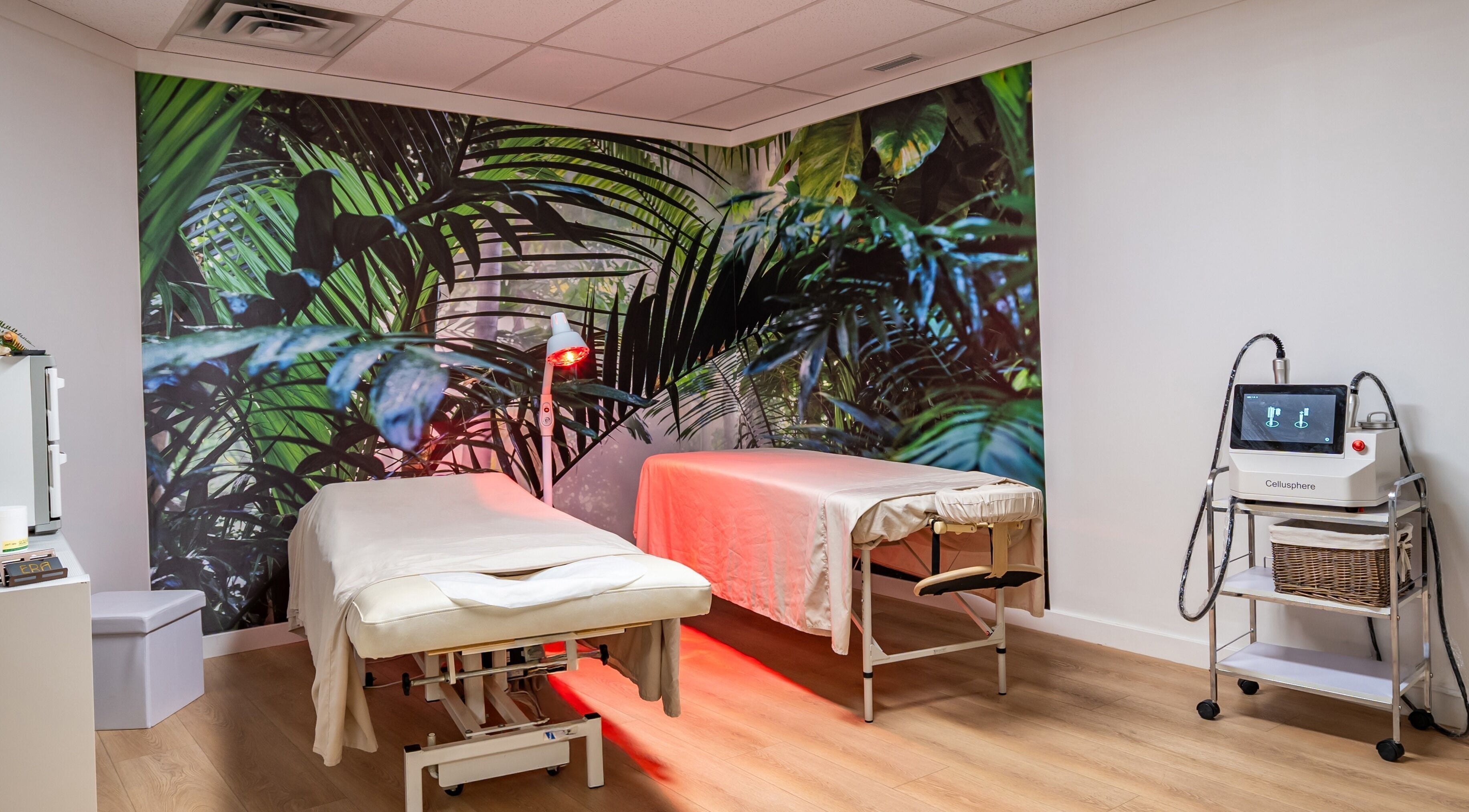 Relaxing treatment room at ERA Massage & Beauty in Calgary, Alberta, CA with tropical decor and massage tables.