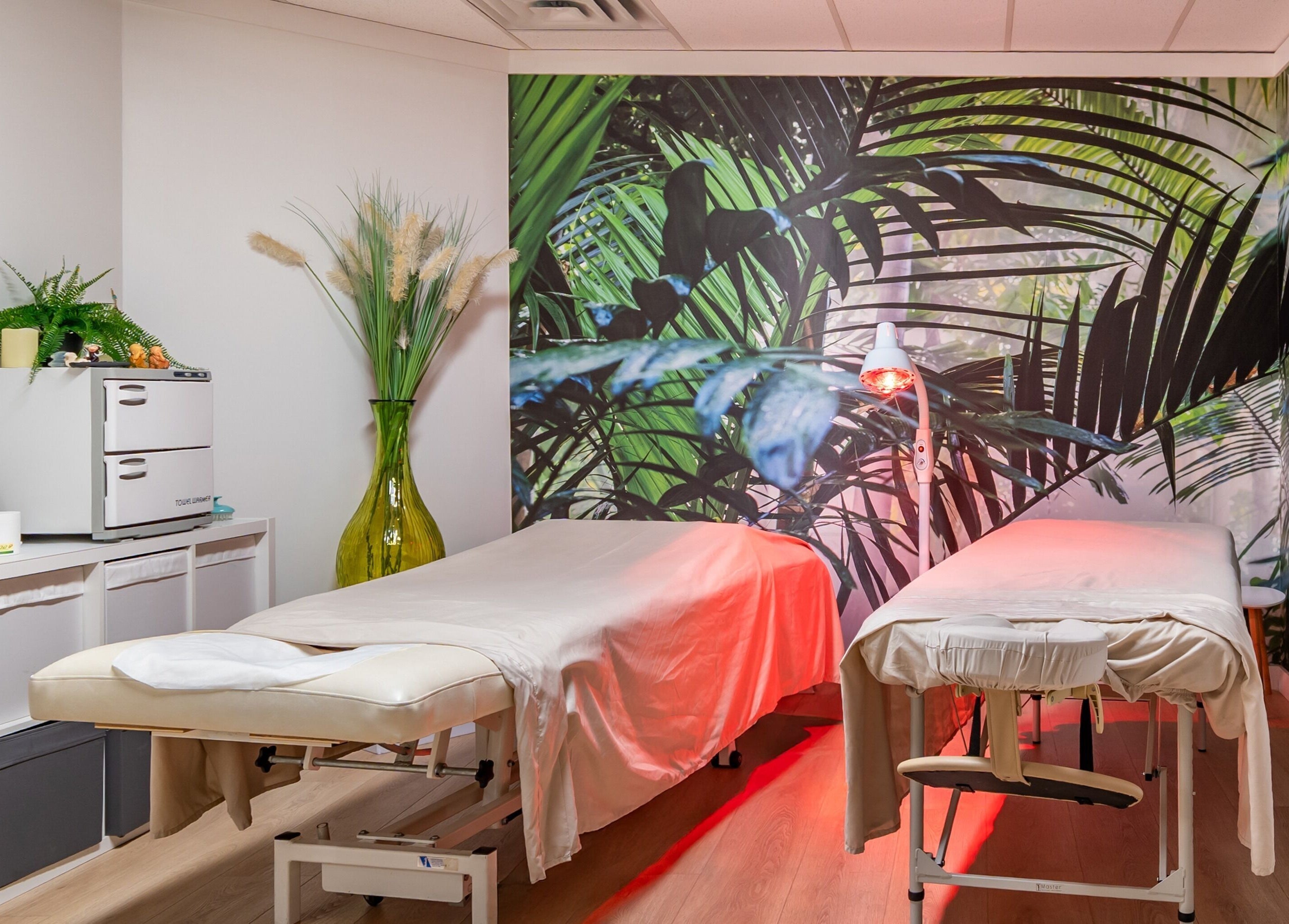 Relaxing massage room at ERA Massage & Beauty in Calgary, Alberta, CA with tropical decor and serene ambiance.