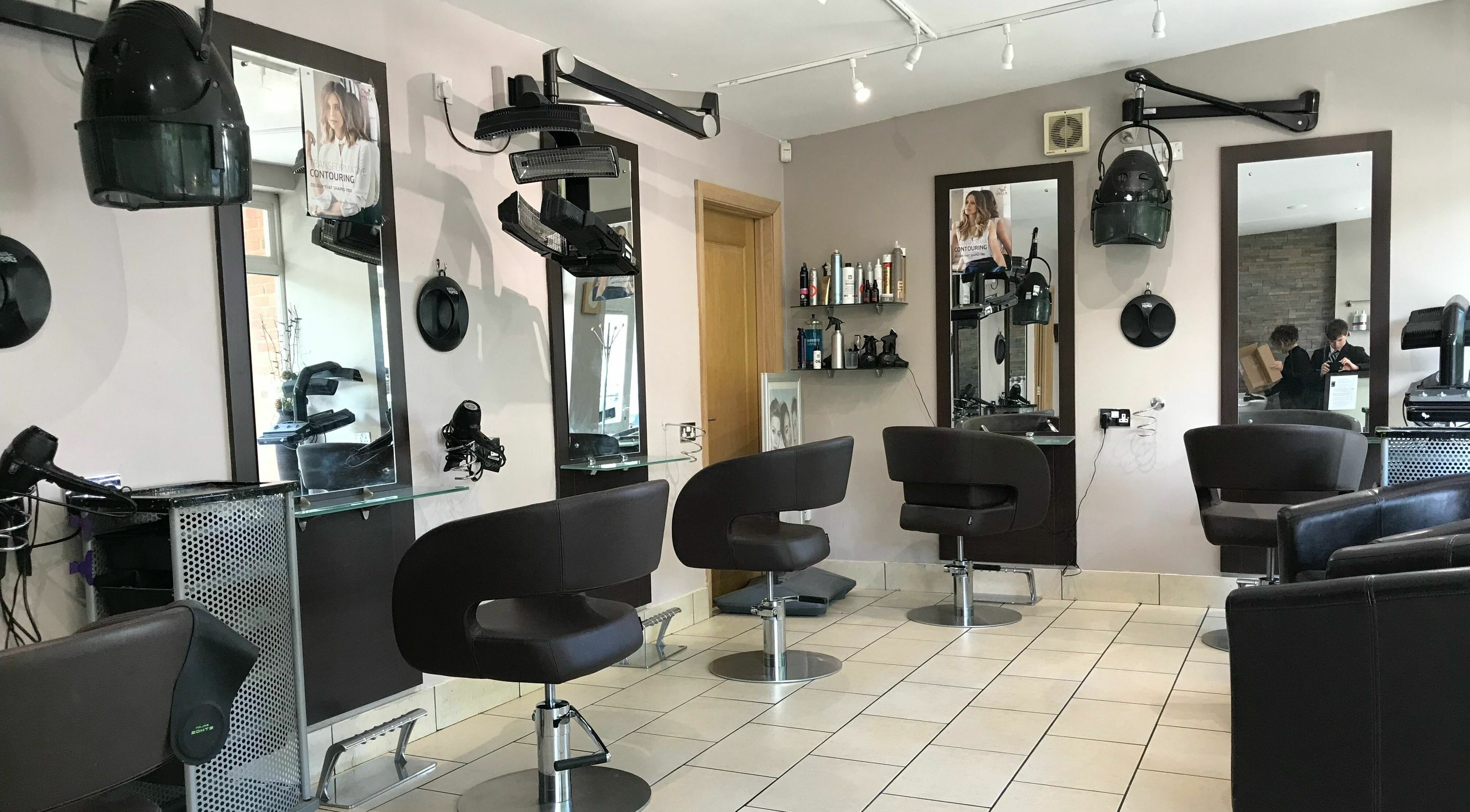 Modern salon chairs and mirrors at Whispers Hair Design, Teignmouth, England, GB, showcasing stylish design.