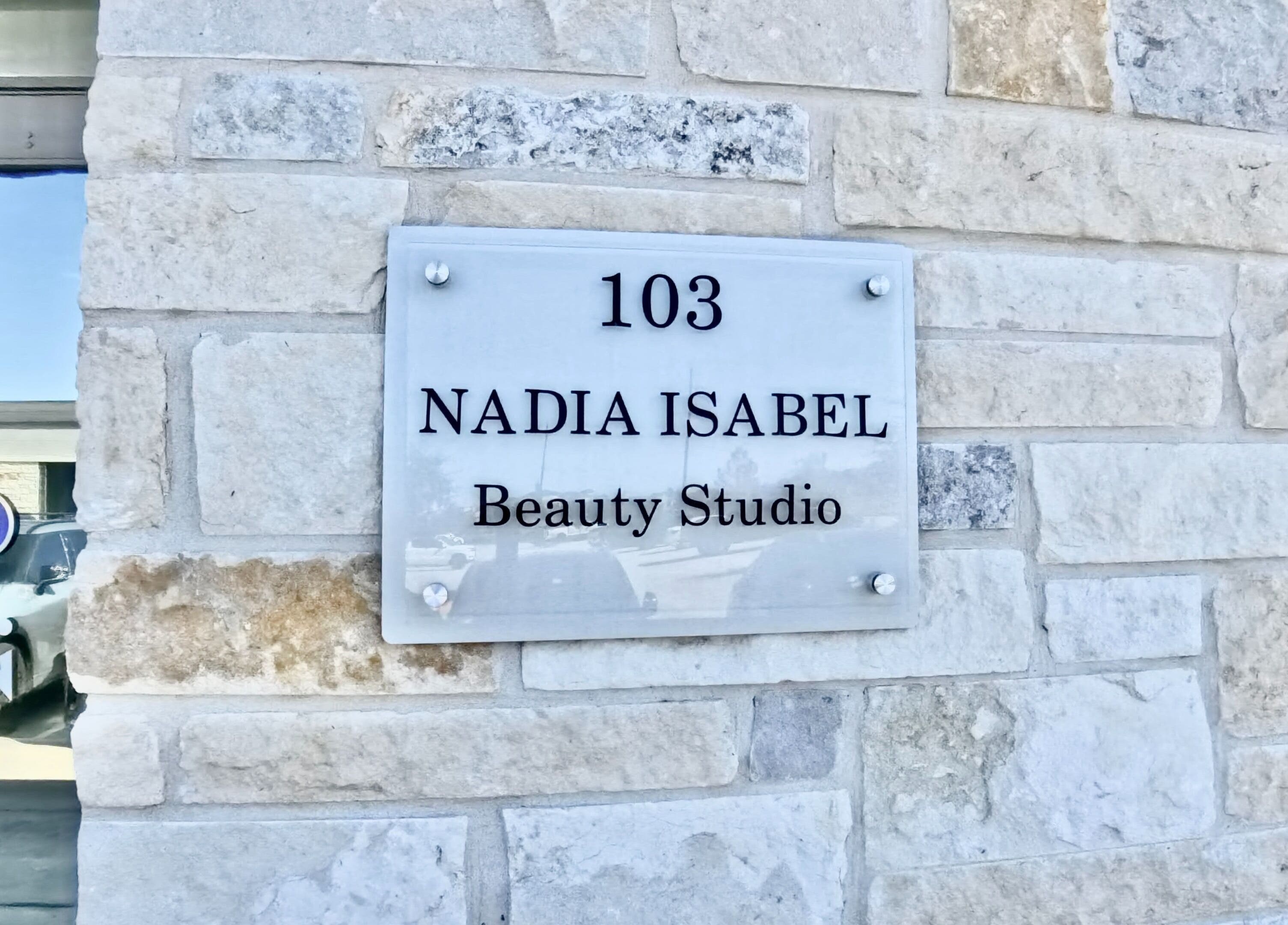 Nadia Isabel Studio entrance sign on a brick wall in Katy, Texas, US.