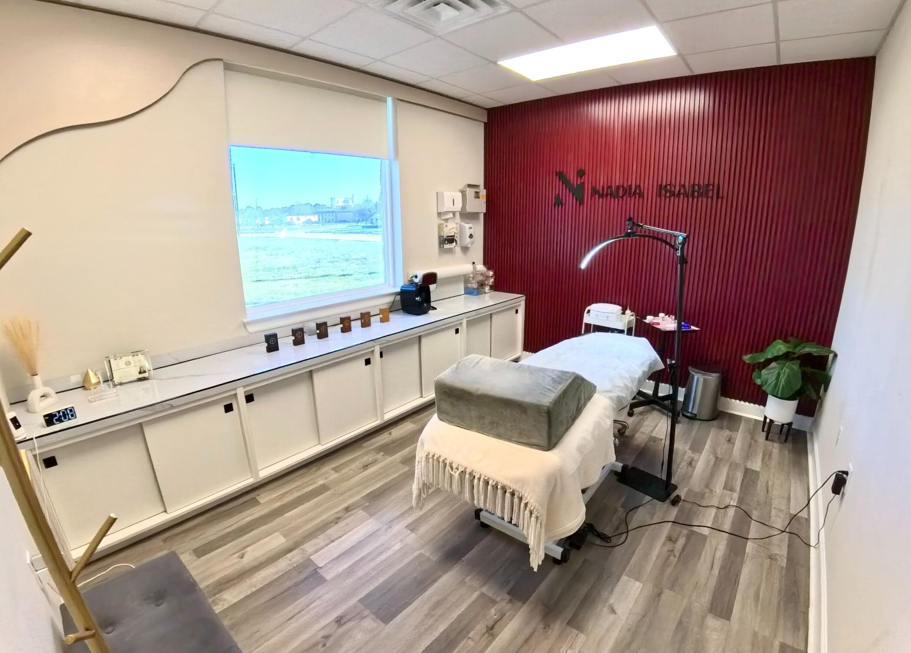 Tranquil treatment room at Nadia Isabel Studio in Katy, Texas, US, featuring a massage bed and elegant decor.