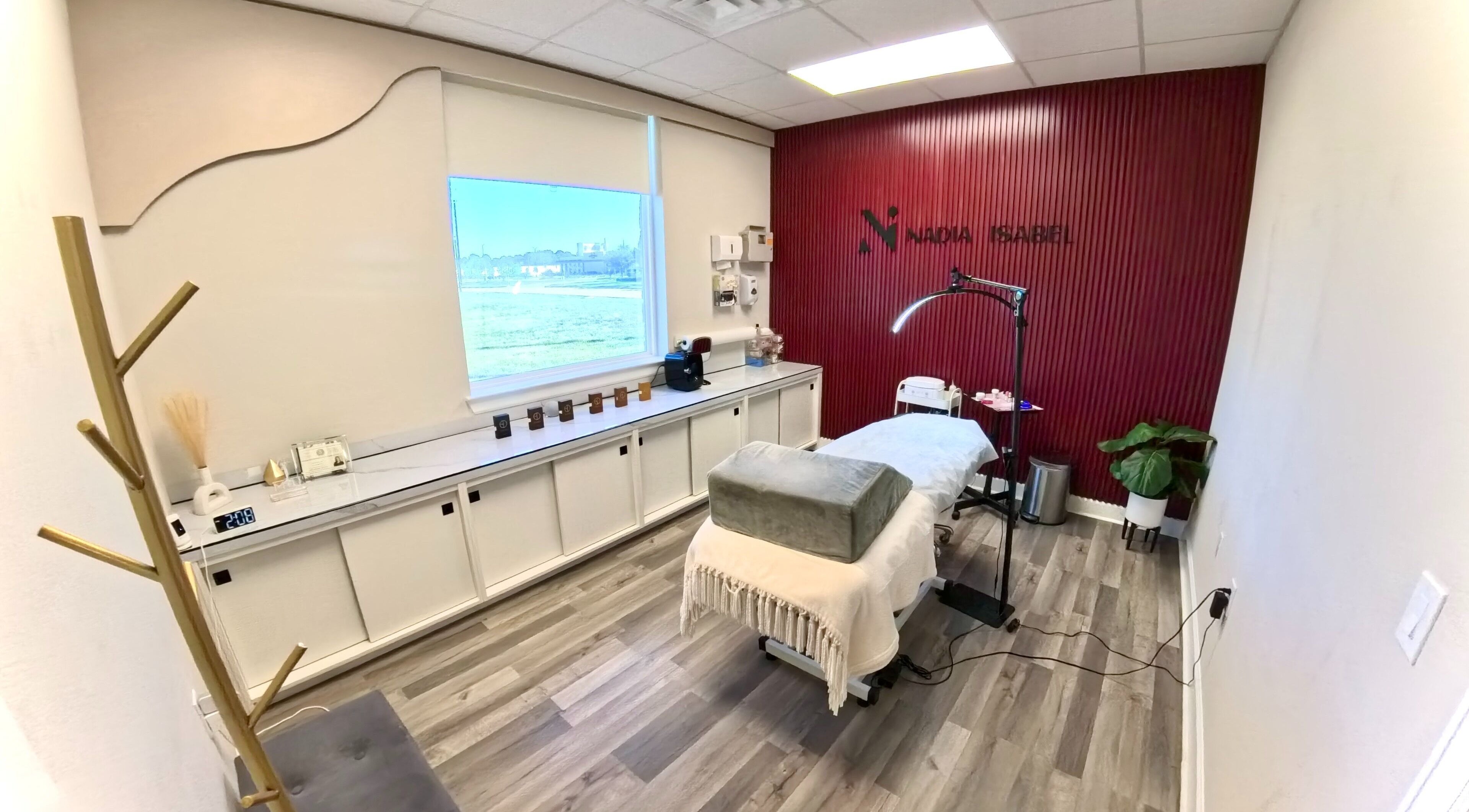 Tranquil treatment room at Nadia Isabel Studio in Katy, Texas, US, featuring a massage bed and elegant decor.