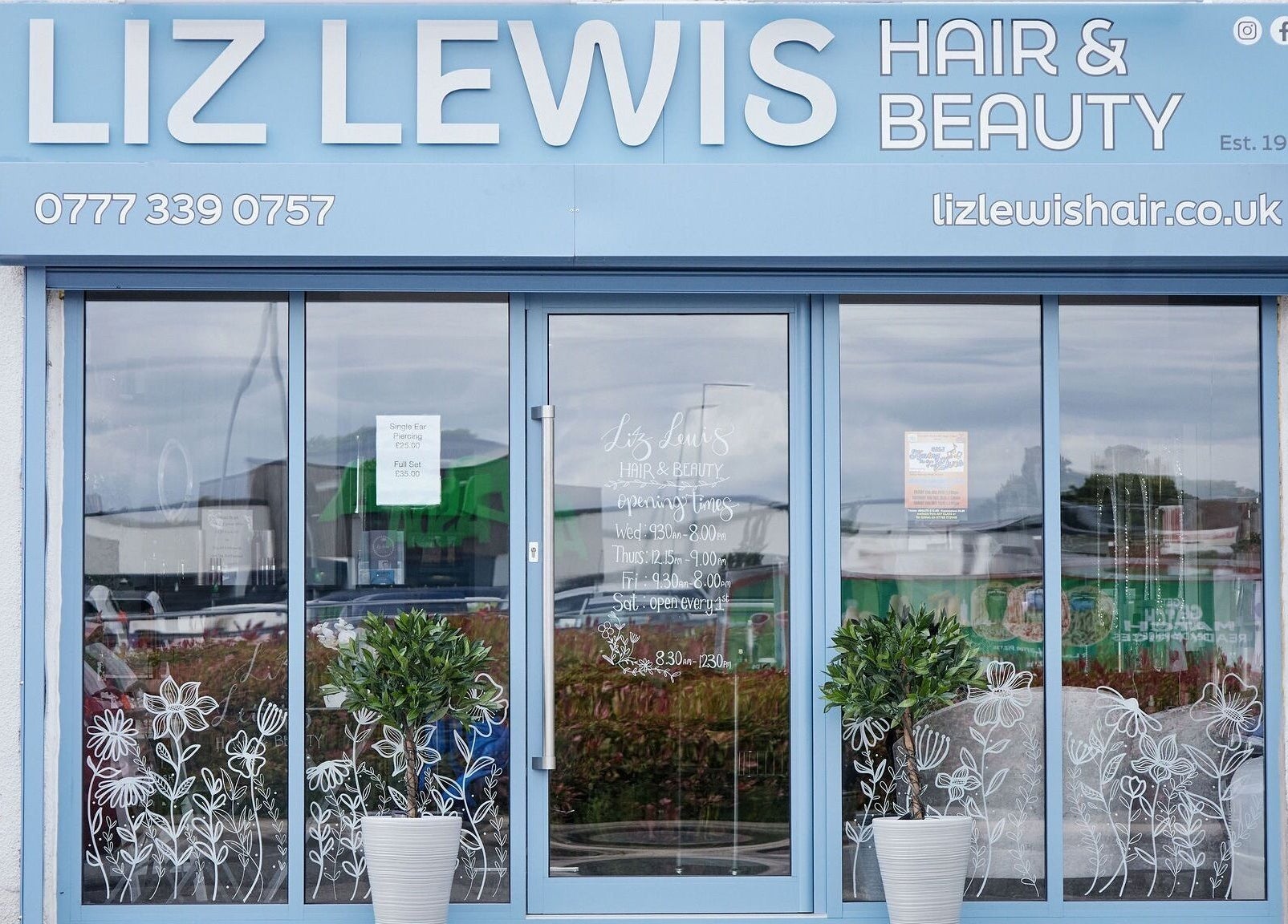 Front entrance of Liz Lewis Hair Studio in Chorley, England, GB showcasing elegant plant decorations.