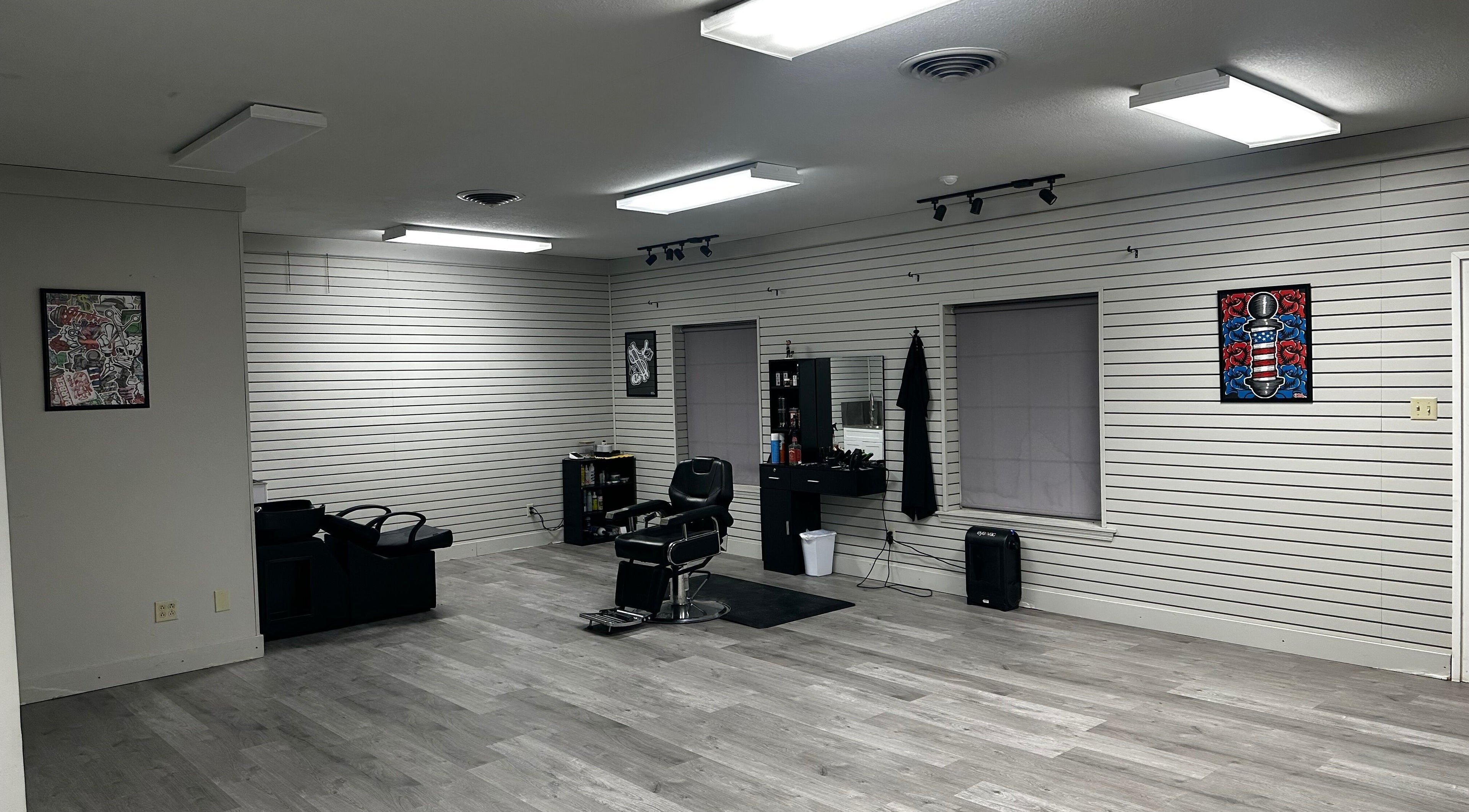 Interior view of Cut-N-Up Barbershop in Arkadelphia, Arkansas, US, showcasing sleek design and comfortable seating.