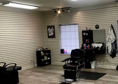 Spacious interior of Cut-N-Up Barbershop in Arkadelphia, Arkansas, US, featuring a barber chair and equipment.