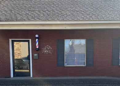 Front view of Cut-N-Up Barbershop, a classic venue in Arkadelphia, Arkansas, US with iconic barber pole.