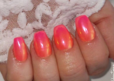 Vibrant pink and orange nails at Cody's nail boutique, Portsmouth, England, GB on lace background.