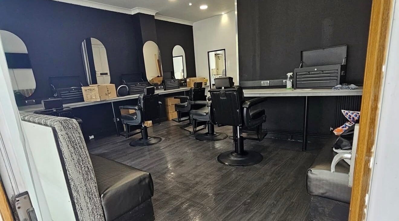 Modern interior of Chax Barbers | Etruria Road in Stoke-on-Trent, England, GB with sleek black chairs.