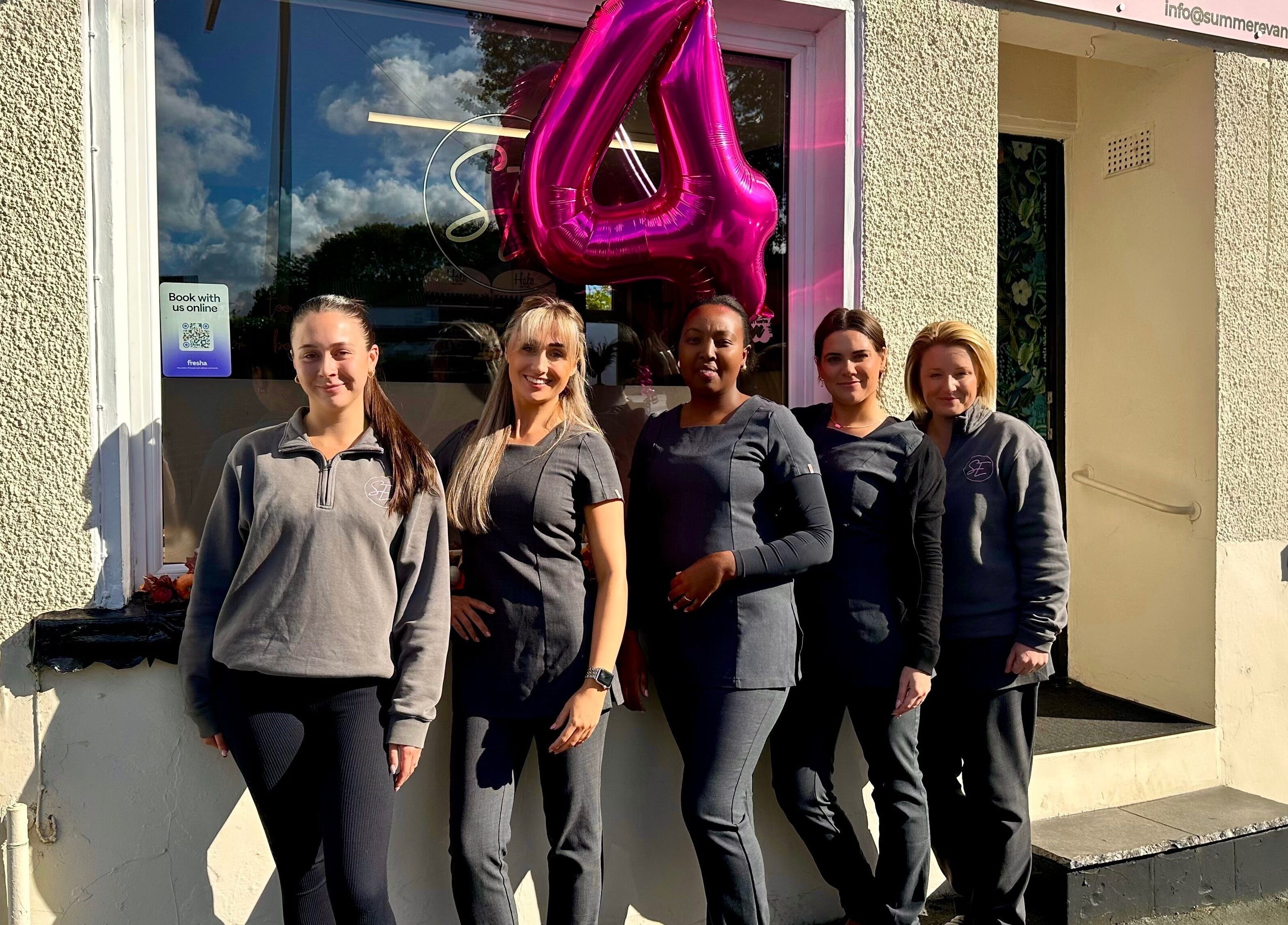 Summer Eva Nafferton staff standing outside venue in Nafferton, England, GB with celebratory balloon.