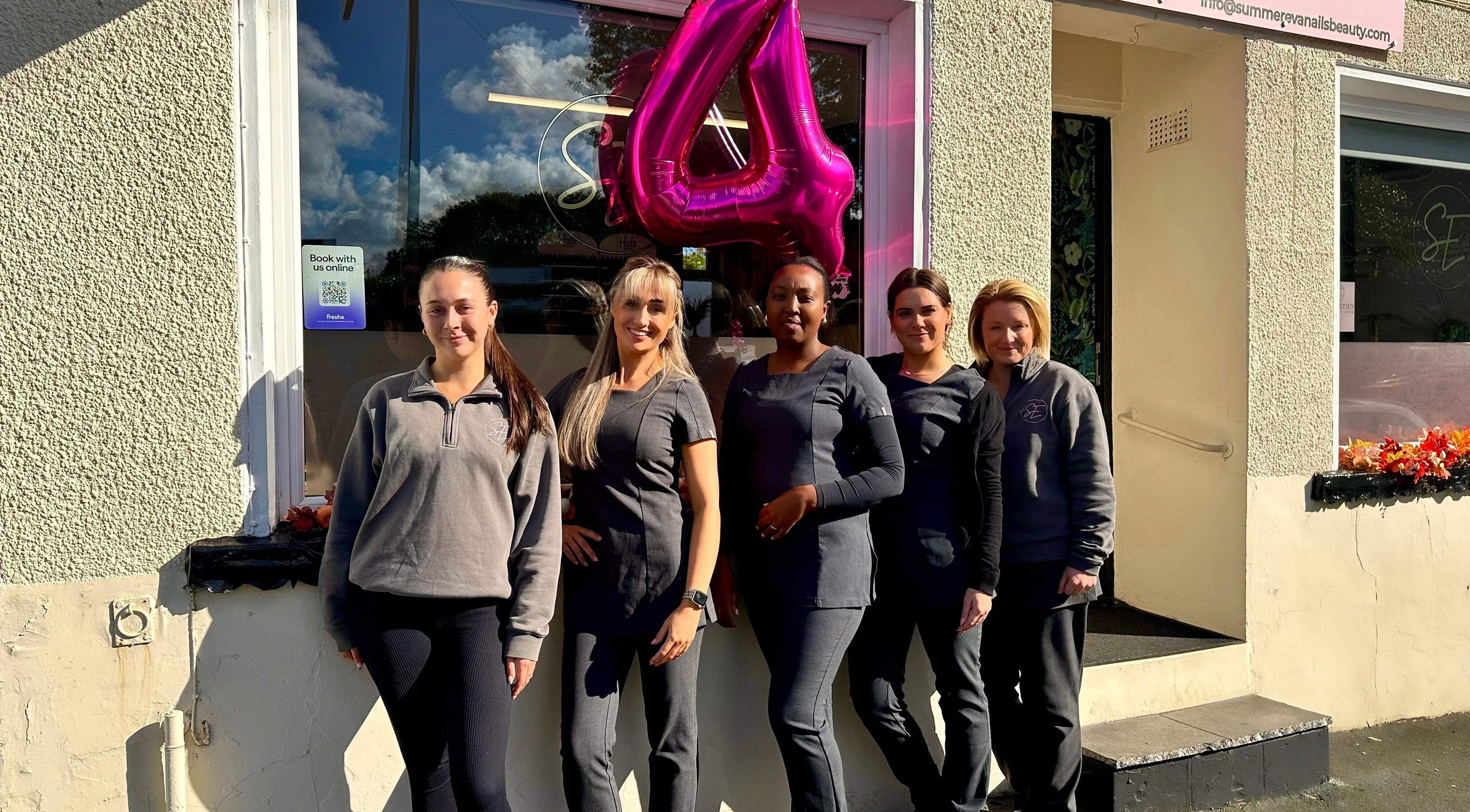 Summer Eva Nafferton staff standing outside venue in Nafferton, England, GB with celebratory balloon.